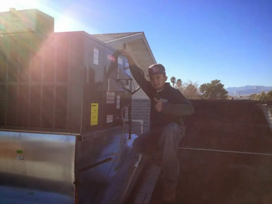 HVAC technician performing AC Tune-Up on a rooftop unit in Calera